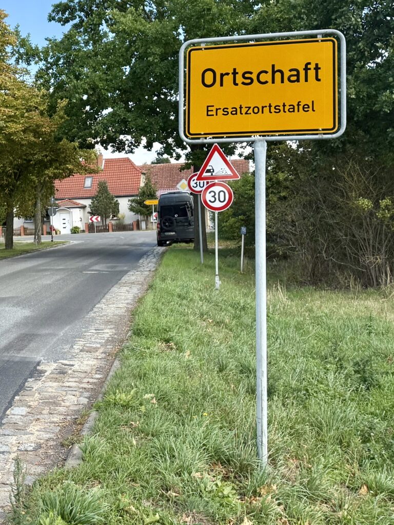Typisches gelbes Ortseingangsschild mit der Aufschrift Ortschaft